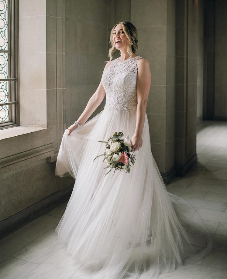 Bride in blush dress twirling in San Francisco City Hall window light 